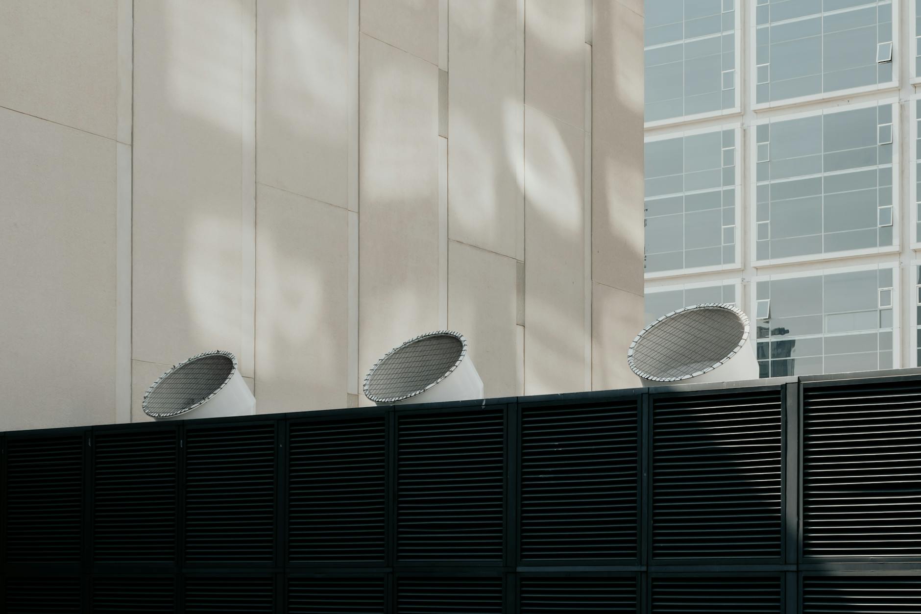 Nowoczesny budynek z widocznymi systemami wentylacji na tle miasta