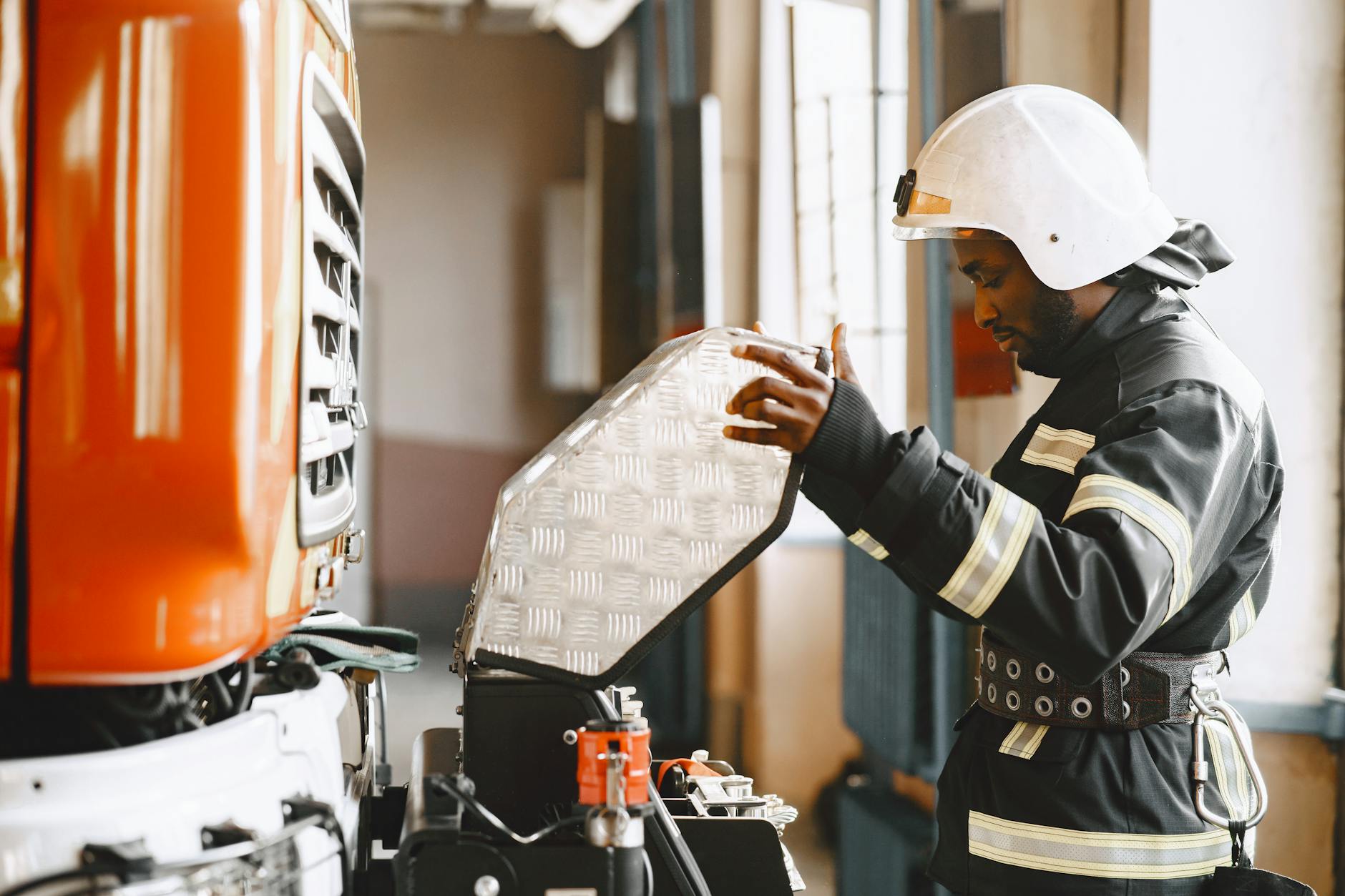 Strażak w garażu serwisuje sprzęt przeciwpożarowy