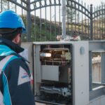 Elektryk w kasku sprawdza zewnętrzną skrzynkę elektryczną